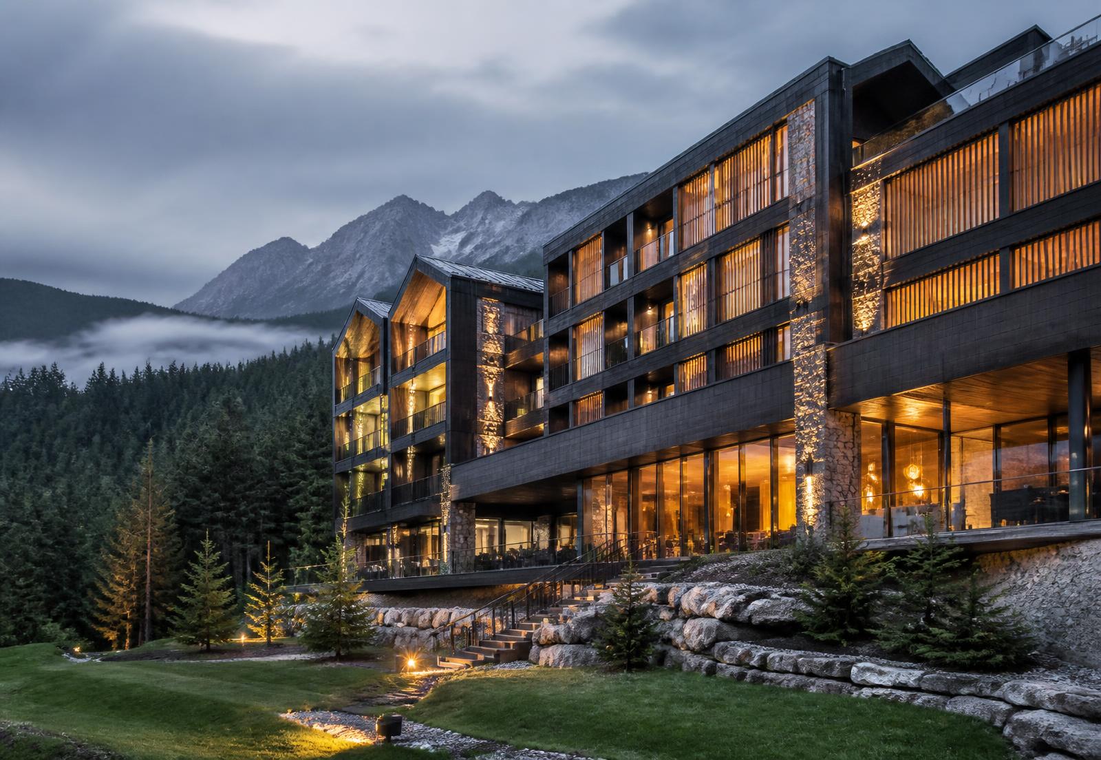 Modernes alpines Boutique-Hotel in dunklem Holz und Stein am Abend